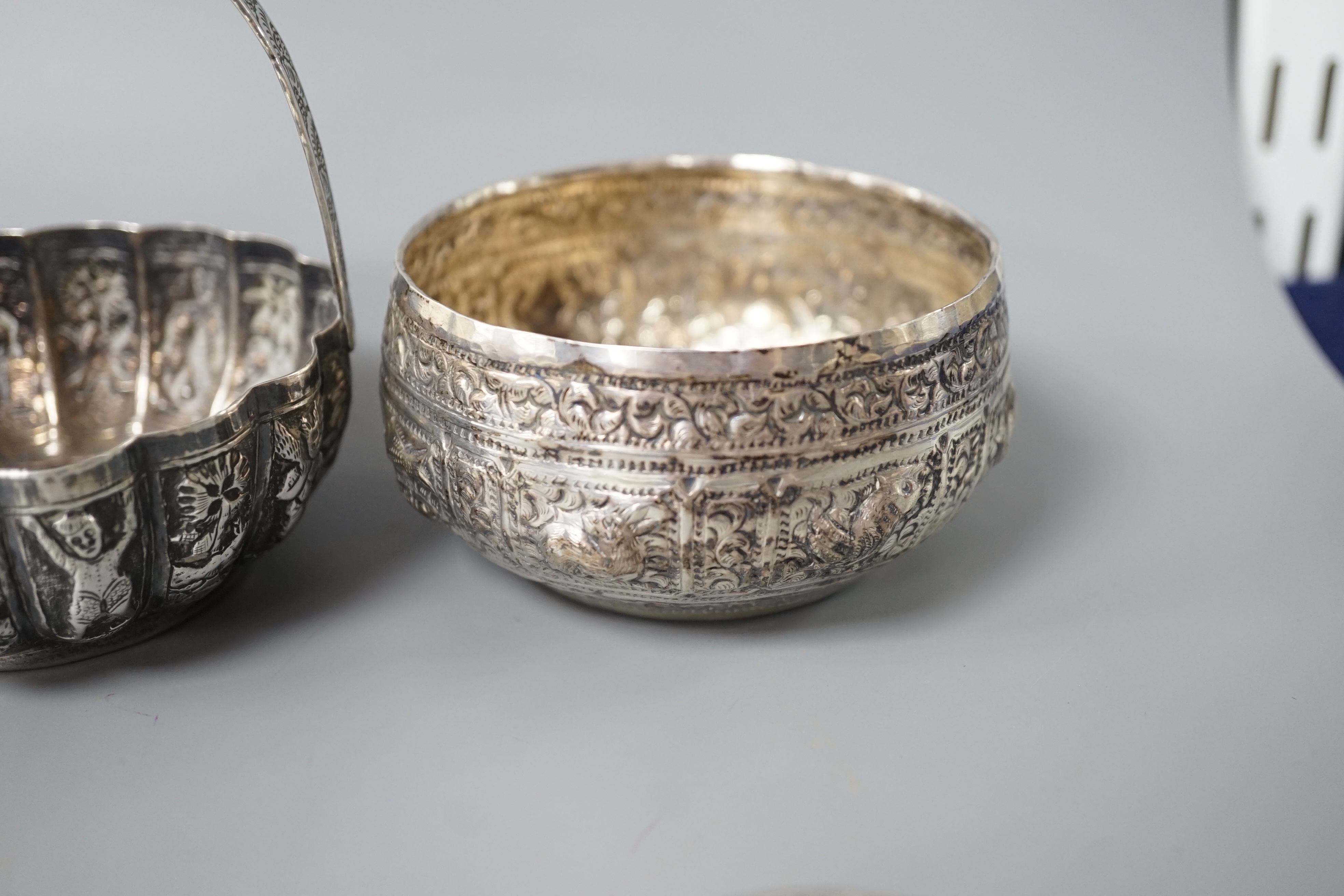 A Burmese? white metal bonbon basket, height 10.1cm and a similar bowl, two Persian white metal boxes and a spoon.